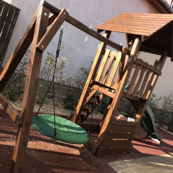 Kis torony fa tetővel, homokozóval fészekhintával és eladó pulttal