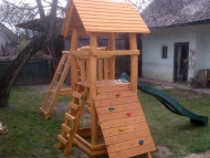 Kis torony fatetővel, mászófallal, homokozóval, hálós mászókával