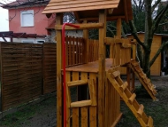 Fatetős kuckós torony és bástya, híddal összekötve, tűzoltórúddal, mászó fallal, mászó hálóval